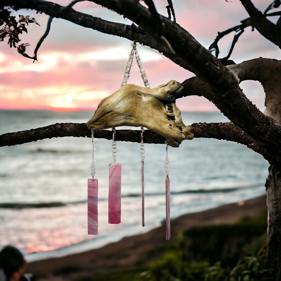 Alaskan Driftwood Chime with Pink Glass with sunset beach background.