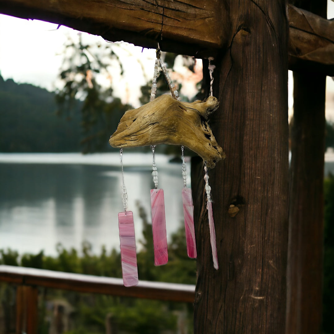Alaskan Driftwood Chime with Pink Glass hanging with lake background.