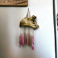 Alaskan Driftwood Chime with Pink Glass on white wall background.