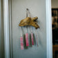 Alaskan Driftwood Chime with Pink Glass on grey background.