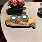 Driftwood Candle Holder with Aqua Colored Fire Glass and Tea Lights. Driftwood Decor on table with flowers background.